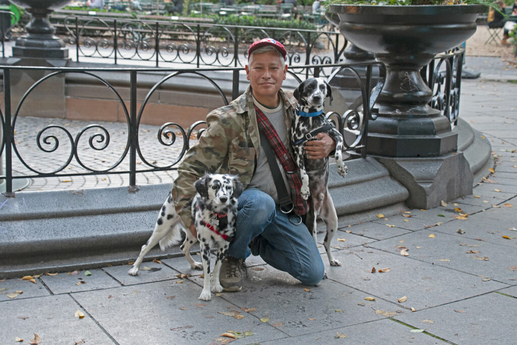 Dog walker in Madison Square Park, NYC. Photo captured with two of his favorite clients. Photo copyright by Paul G. Barretta, PBnJphoto.com