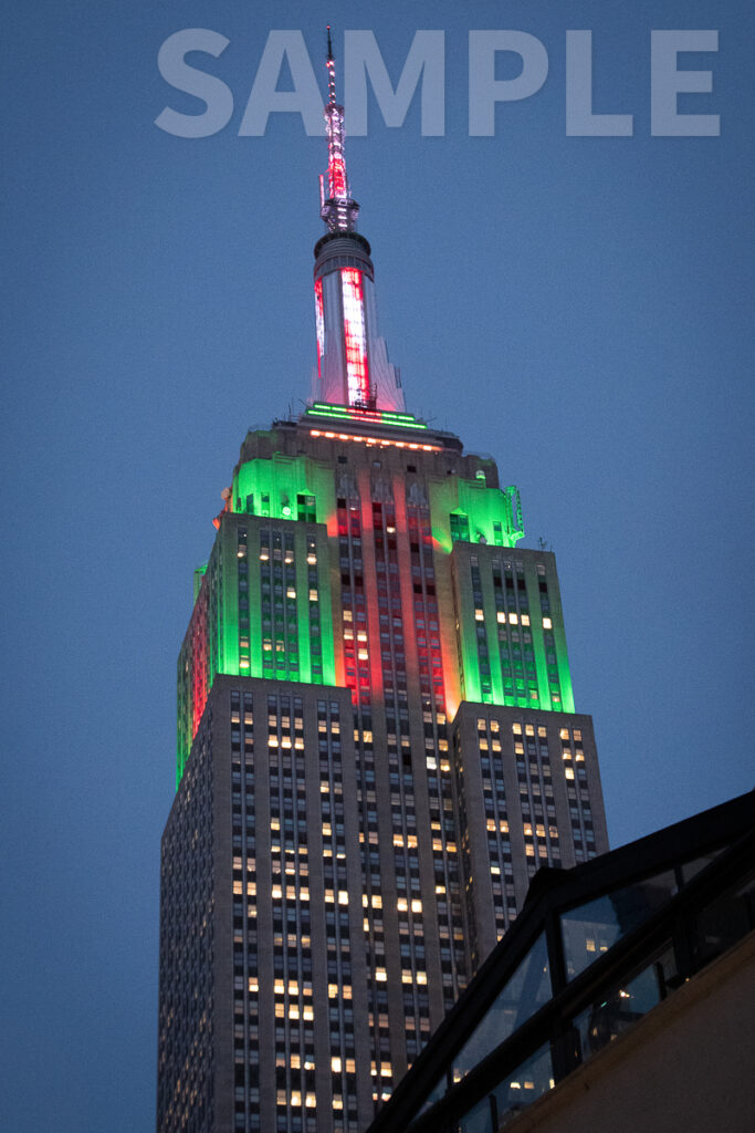 Empire State Building in New York City at dusk lit Red and Green.  Photo copyright 2021 by Paul Barretta